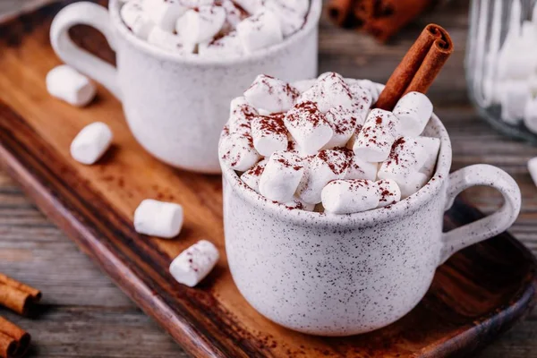 Bebida de Natal. Chocolate quente com marshmallows e canela no fundo de madeira escura . — Fotografia de Stock