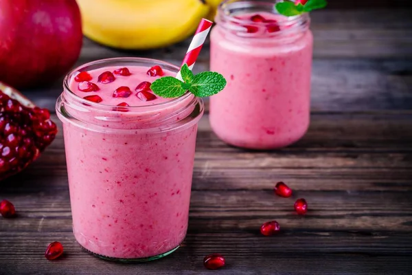 Pink pomegranate smoothie in a glass jar with mint and fresh seeds — Stock Photo, Image