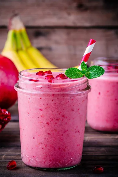 Pink pomegranate smoothie in a glass jar with mint and fresh seeds — Stock Photo, Image