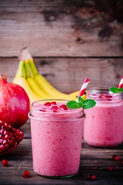 Smoothie romã rosa em um frasco de vidro com hortelã e sementes frescas — Fotografia de Stock