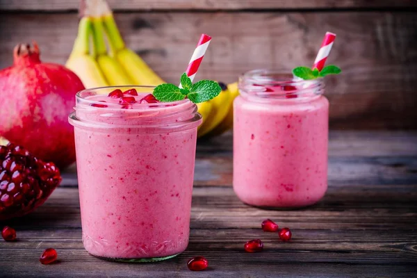 Pink pomegranate smoothie in a glass jar with mint and fresh seeds — Stock Photo, Image