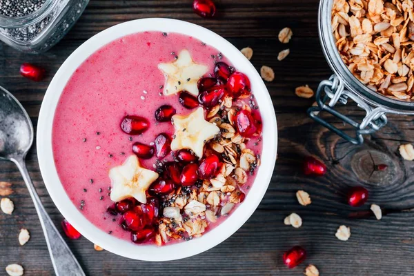 Tazón de batido rosa con granada, granola casera, estrellas del plátano y semillas de chía — Foto de Stock