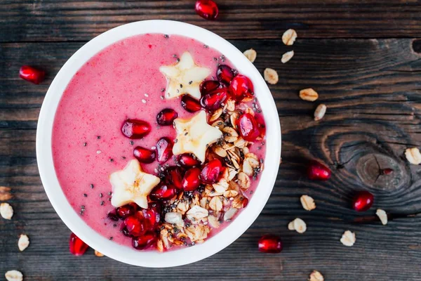 Tazón de batido rosa con granada, granola casera, estrellas del plátano y semillas de chía — Foto de Stock