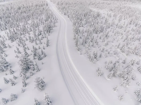 Vista aérea de la carretera en el bosque de nieve de invierno en Finlandia —  Fotos de Stock
