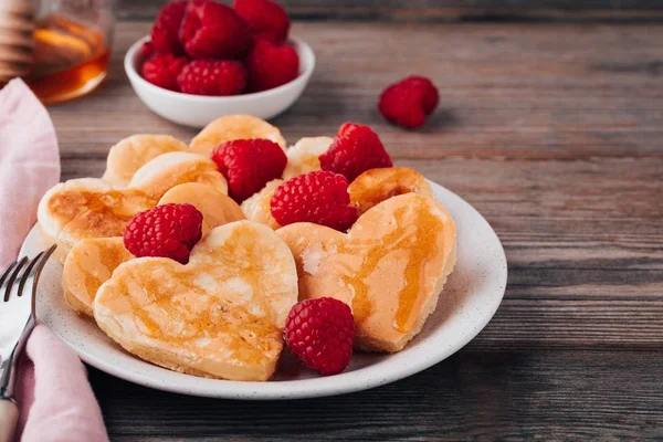 Panqueques en forma de corazón con frambuesas y miel para el Día de San Valentín — Foto de Stock