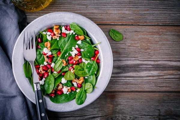 Fresh green salad with spinach, walnuts, goat cheese and pomegranate — Stock Photo, Image