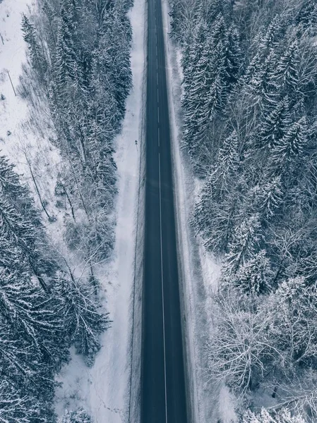 Camino de campo que pasa por los hermosos paisajes cubiertos de nieve. Vista aérea . —  Fotos de Stock