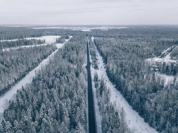 Ülke yol güzel kar üzerinden gidiyor manzara kaplı. Havadan görünümü. — Stok fotoğraf