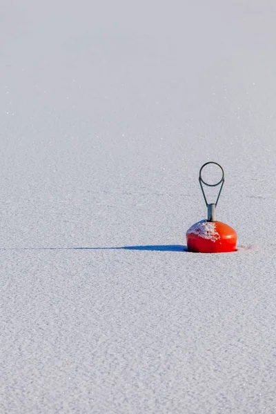 Rode boei in de haven van de bevroren meer in de winter, Finland. — Stockfoto