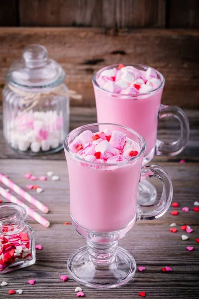 Pink hot chocolate with marshmallow and sugar hearts in a glass mug for Valentine Day