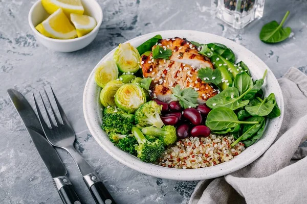 Gezonde lunch van de kom van de Boeddha met gegrilde kip, quinoa, spinazie, avocado, spruiten, broccoli, rode bonen met sesamzaadjes — Stockfoto