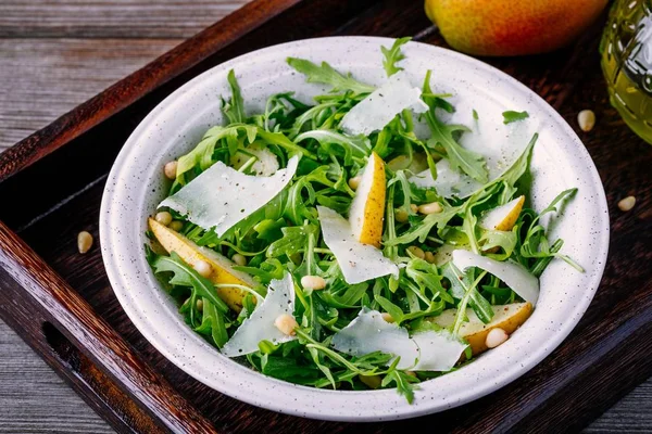Зелений салат чаша руколи з грушею, пармезановим сиром і кедровими горіхами — стокове фото