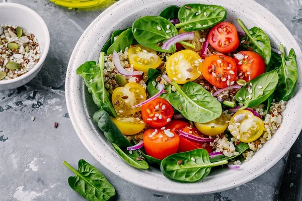 Salade de bol vert sain aux épinards, quinoa, tomates jaunes et rouges, oignons et graines — Photo