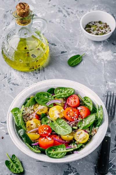 Gezonde groene salade met quinoa, geel en rood tomaten, uien, spinazie en zaden — Stockfoto