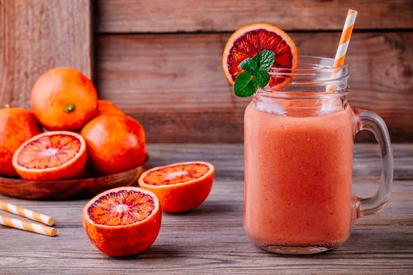 Smoothie fresco com banana, laranjas de sangue e hortelã em um frasco de pedreiro — Fotografia de Stock