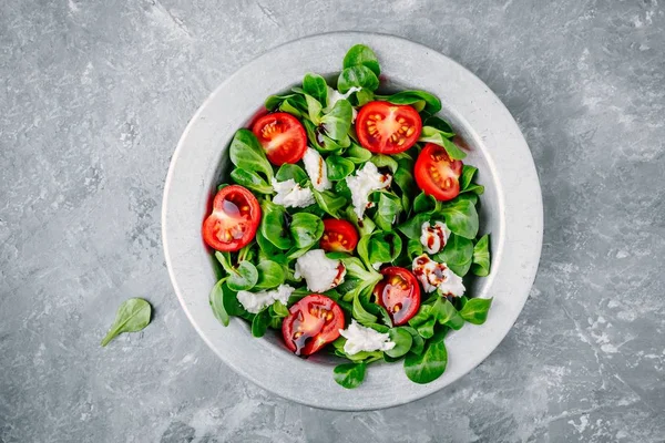 Frische Salatschüssel mit grünen Blättern, Mozzarella, Tomaten und Balsamico-Sauce — Stockfoto
