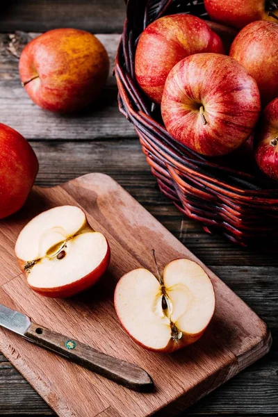 Rode rijpe appels in een mand op een houten ondergrond — Stockfoto