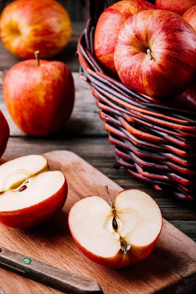 Červená zralá jablka v košíku na dřevěném pozadí — Stock fotografie