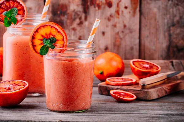 Batido fresco con plátano, naranjas de sangre y menta en un frasco de albañil —  Fotos de Stock