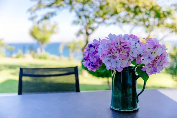 Bouquet of pink and purple flowers in a vase on the table in the garden — Stock Photo, Image