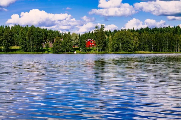 Tradiční finská dřevěná chata se saunou a stodola na břehu jezera. Letní venkovských Finsko. — Stock fotografie