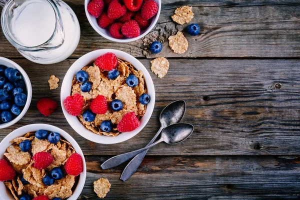 一个健康的早餐碗。全谷类谷物, 新鲜蓝莓和覆盆子在木质背景。顶部视图 — 图库照片