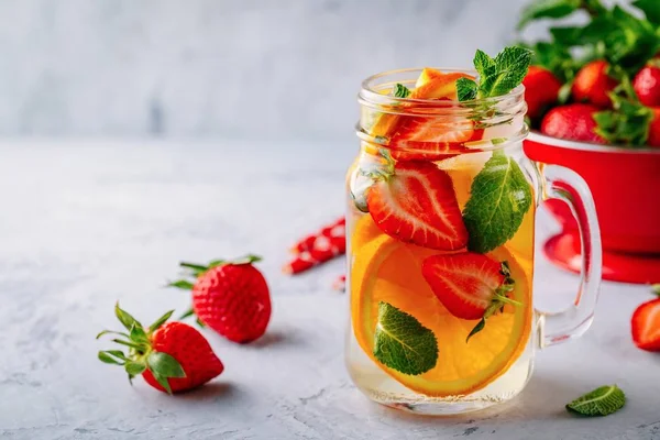 Água desintoxicada infundida com laranja, morango e hortelã. Cocktail frio de verão ou limonada . — Fotografia de Stock