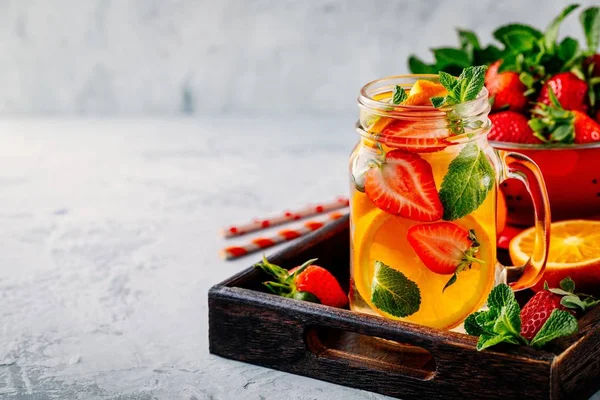 Água desintoxicada infundida com laranja, morango e hortelã. Cocktail frio de verão ou limonada . — Fotografia de Stock