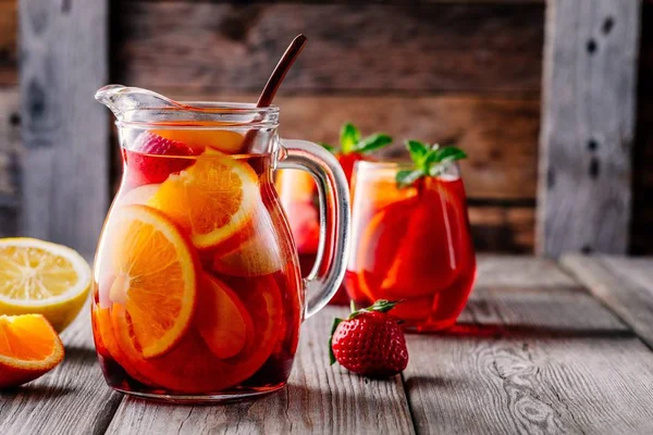 포도주 샹그리아 오렌지 딸기와 얼음을 나무로 주전자와 유리잔을 짓는다 — 스톡 사진