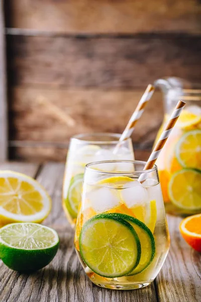 Ein erfrischendes eiskaltes Sommergetränk. Weißweinsangria im Glas mit Limette, Zitrone und Orange — Stockfoto
