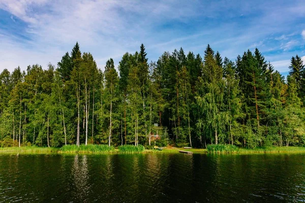 Идиллический деревенский пейзаж с голубым озером и домом на берегу. Летний коттедж в Финляндии . — стоковое фото