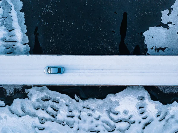 Finlandiya 'da kış mevsiminde donmuş nehrin üzerindeki köprü yolunun havadan görünüşü. — Stok fotoğraf