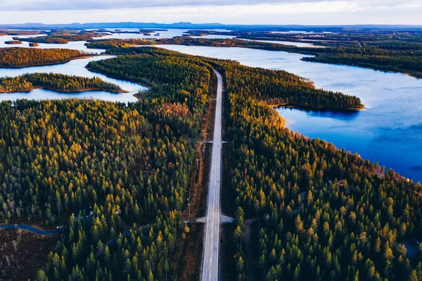 Luchtfoto van weg door herfstbos met blauwe meren in Finland. — Stockfoto