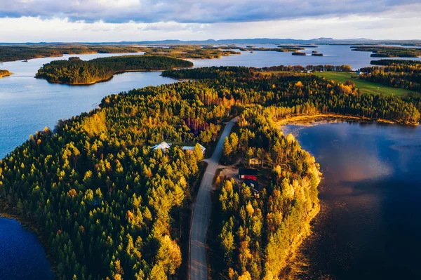 Letecký pohled na cestu podzimním lesem s modrými jezery ve Finsku. — Stock fotografie