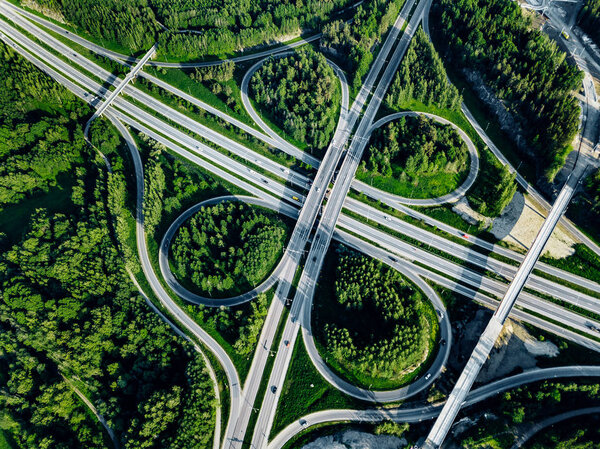 Aerial top view of Highway and overpass with green forests in Finland.