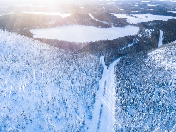 Flygfoto över snövinterfjällslandskapet med skogar, frusna sjöar och vägar i Finland. — Stockfoto
