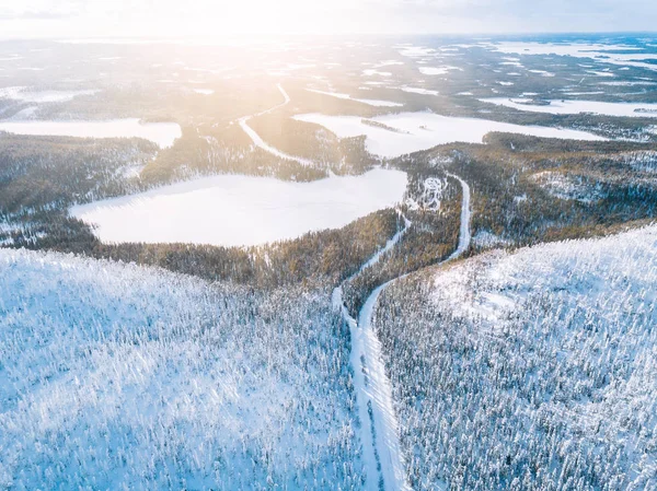 Flygfoto över snövinterfjällslandskapet med skogar, frusna sjöar och vägar i Finland. — Stockfoto