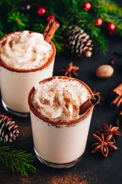 Bebida tradicional de Natal Eggnog com chantilly e canela no fundo de pedra escura . — Fotografia de Stock