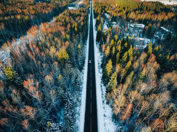 Légi kilátás hófákkal borított erdők és téli országút autóval — Stock Fotó