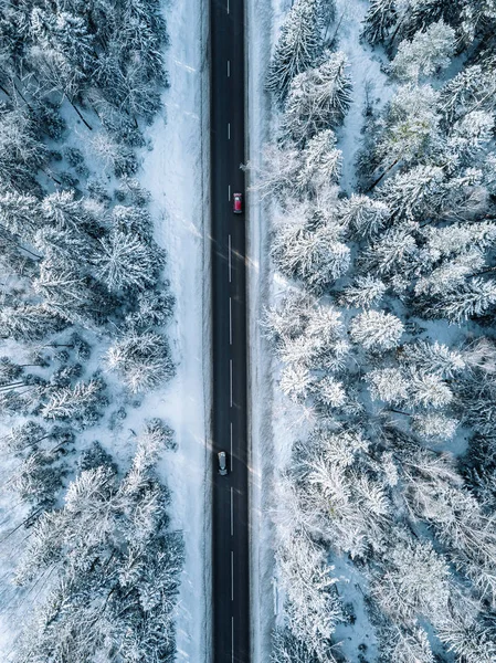 Aerial view of winter road and forest with snow covered trees in Finland — Stockfoto