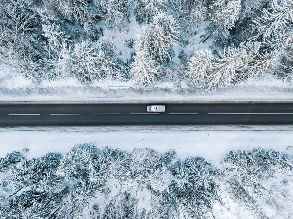 Vista aérea de la carretera de invierno y el bosque con árboles cubiertos de nieve en Finlandia —  Fotos de Stock