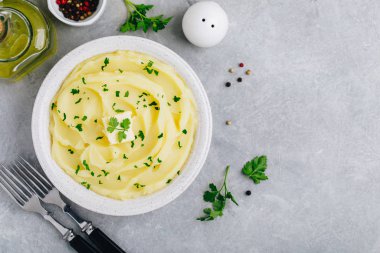 Patates püresi, tereyağlı ve taze maydanozlu gri taştan arka planda beyaz bir kasede.. 