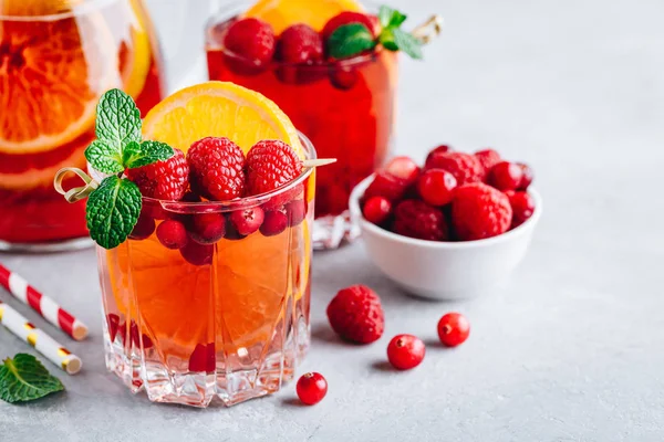 Framboesa Cranberry Sangria Punch ou Mojito em vidro com fatias de laranja e hortelã — Fotografia de Stock