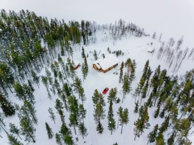 Finlandiya 'nın kırsal kesimindeki göl kenarındaki kar ormanlarındaki ahşap kulübe veya kulübe manzarası 
