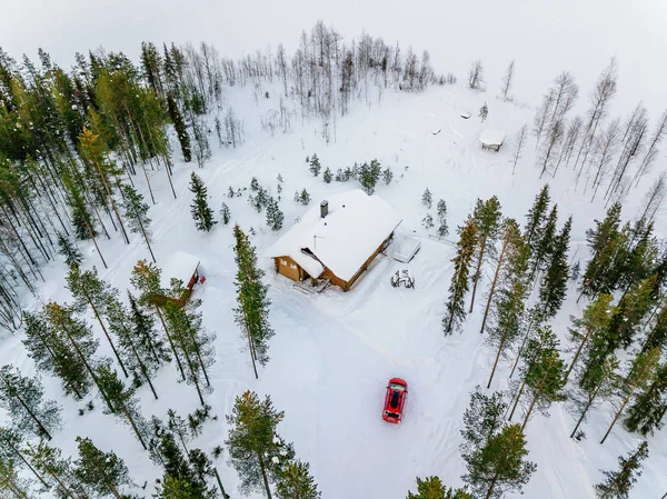 Widok z lotu ptaka drewniana chatka lub domek w śniegu zimowy las nad jeziorem w wiejskiej Finlandii — Zdjęcie stockowe