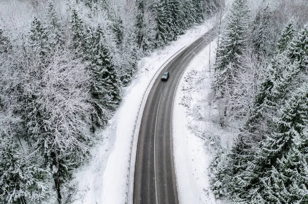 Letecký pohled na zimní silnici s autem a zasněženým lesem ve Finsku — Stock fotografie