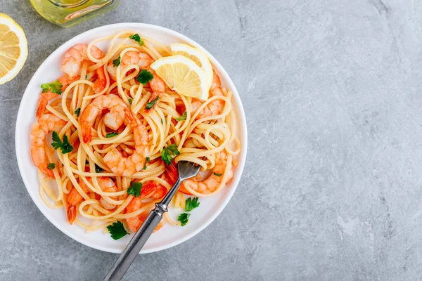 Meeresfrüchte Pasta Spaghetti mit Garnelen und Petersilie auf grauem Steinhintergrund. — Stockfoto