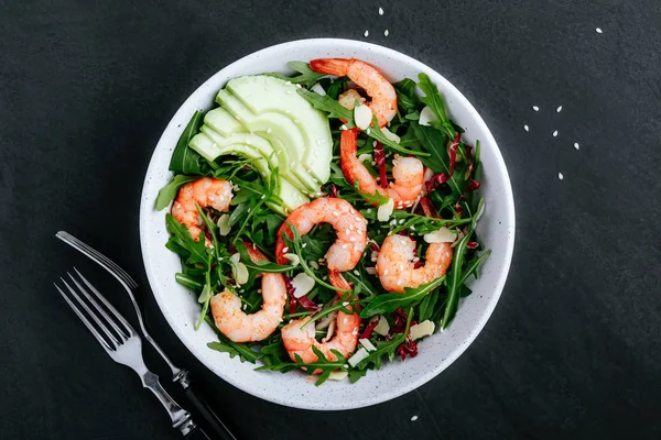 Shrimp salad with fresh green arugula leaves and avocado, radicchio, almond and sesame seeds. — Stock Photo, Image