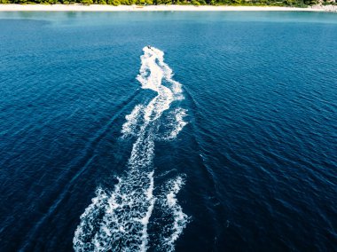 Mavi denizde jet ski yapan birinin hava manzarası. Turkuazda jet ski, temiz su yarışı. 