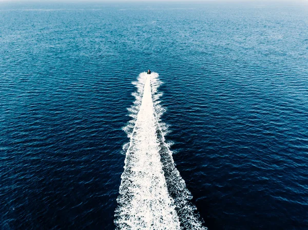 Vista aérea del motero acuático en mar azul. Jet ski en color turquesa carreras de agua clara — Foto de Stock